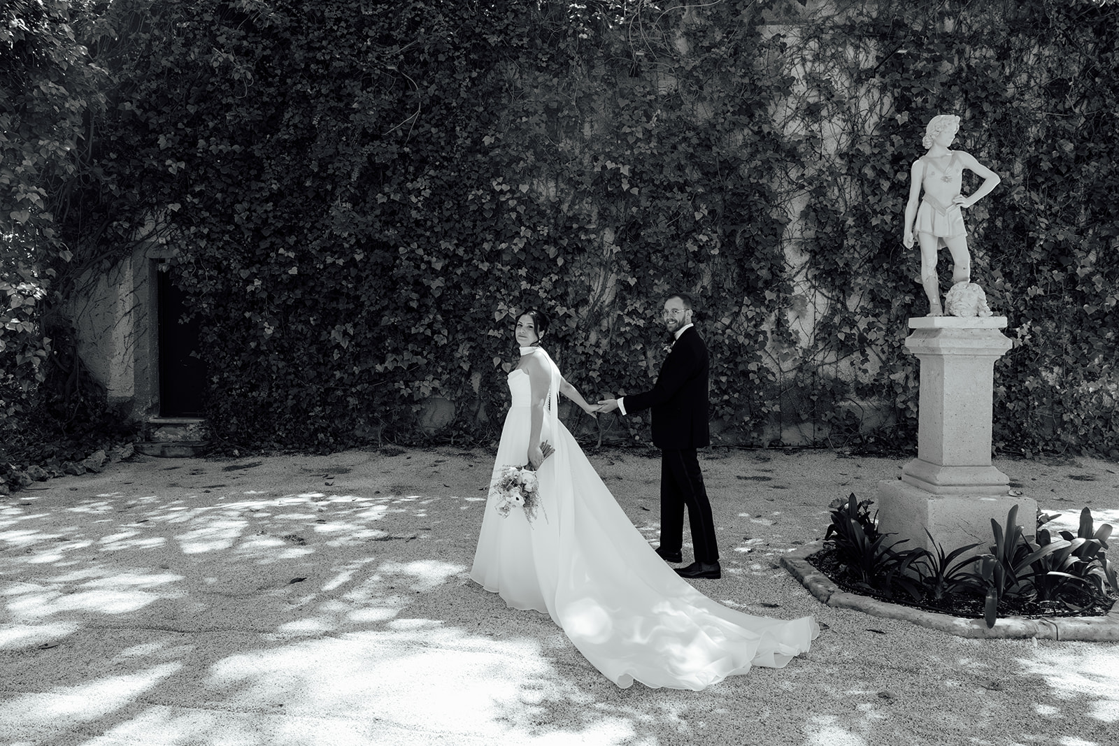Bride and groom walking through the gardens at Jardines de Abril wedding venue in Alicante